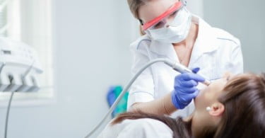 jovem dentista a atender paciente Saúde Oral